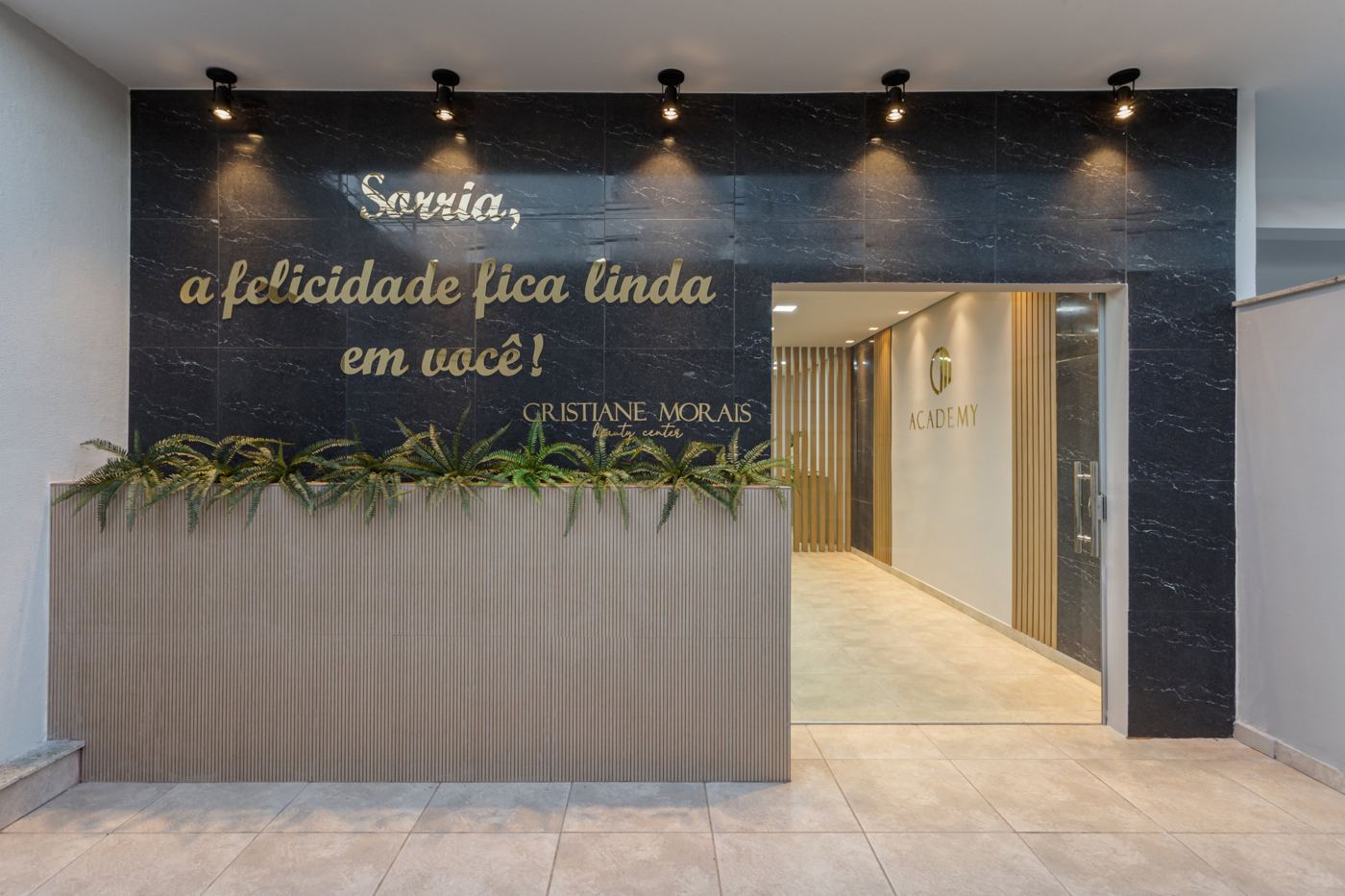 Entrada do studio com a frase Sorria, a felicidade fica linda em você